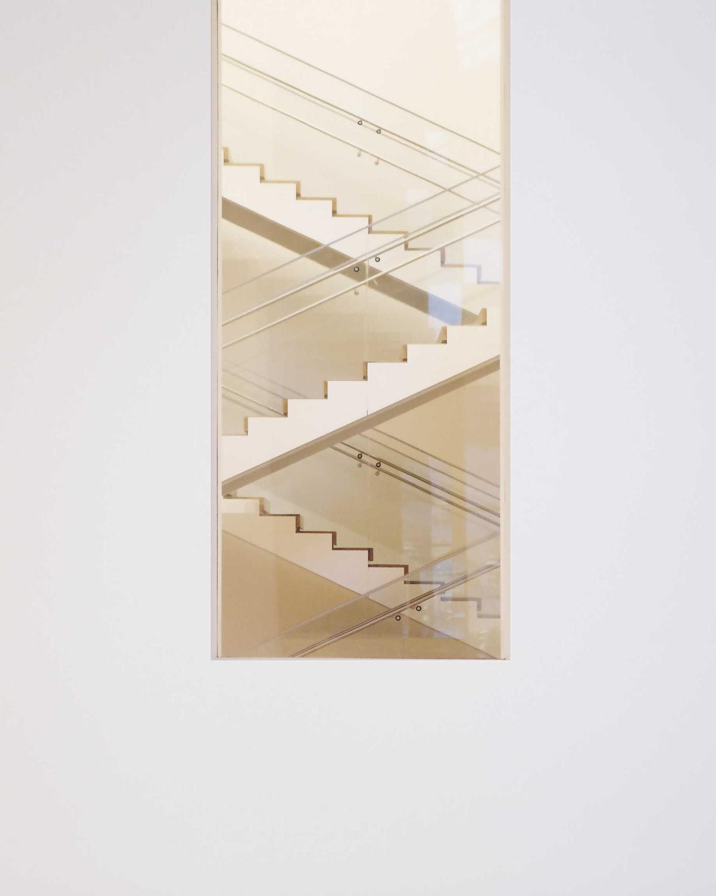 Luz suave sobre una escalera blanca, vista a través de una puerta